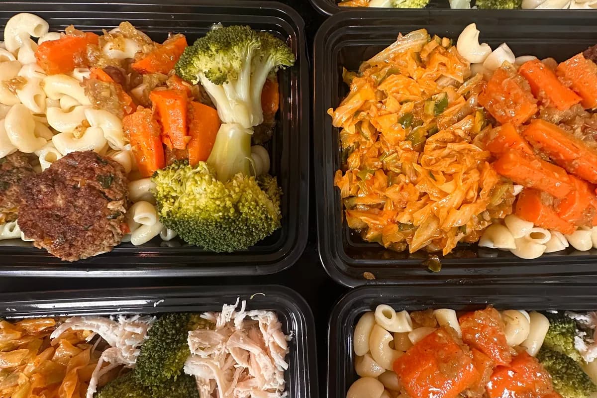 Meal-prep containers filled with grains, vegetables, and protein