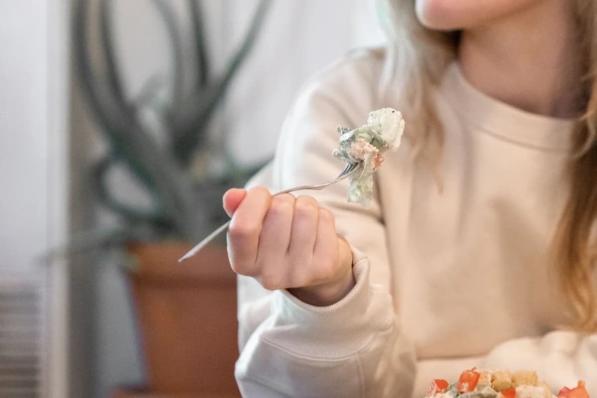 A person eating a meal slowly and attentively