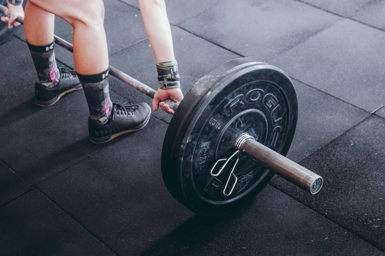 An athlete preparing to lift a barbell in a gym