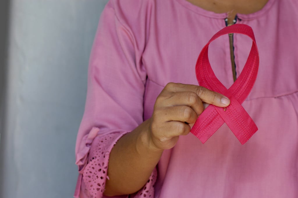 Woman holding a pink cancer awareness ribbon