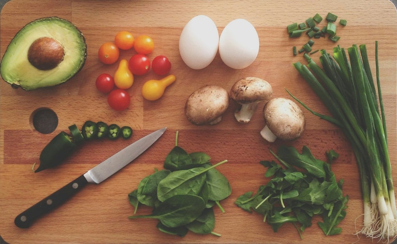 Fresh vegetables, eggs and herbs on a wooden cutting board