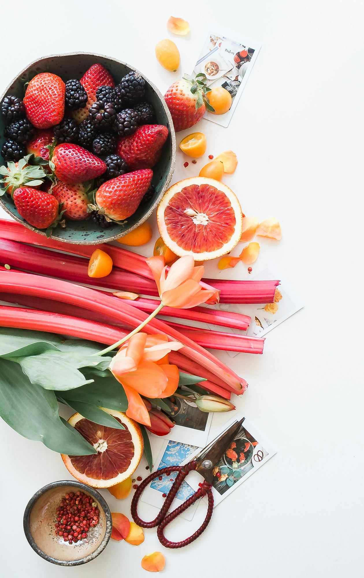 Strawberries, blackberries, grapefruit and rhubarb on a white table